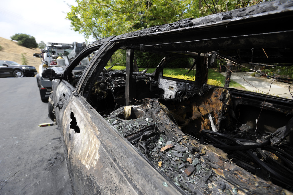 Burnt Lincoln limousine on the side of the Chicago road. Nine passengers escaped without any injuries